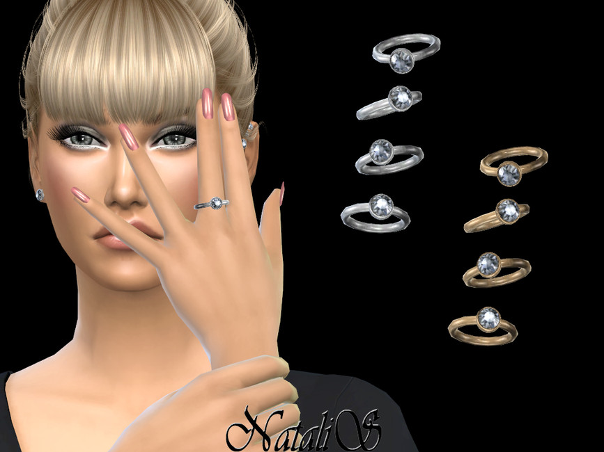 Un sim con cabello rubio recogido en un moño con flequillo y maquillaje de ojos pronunciado y uñas rosadas. Lleva una camisa negra de manga larga y una opción de anillo de boda sencillo de plata para Los Sims 4.