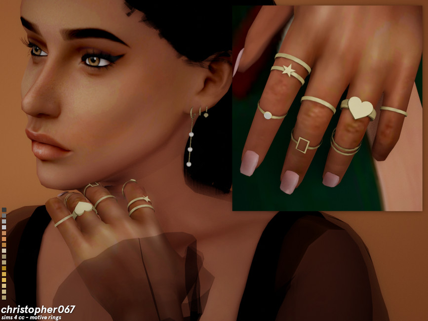 Un sim mostrando su mano con un conjunto de variados anillos de oro. 